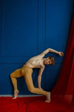 Ballet dancer poses at blue wall in dancing class Stock Photos