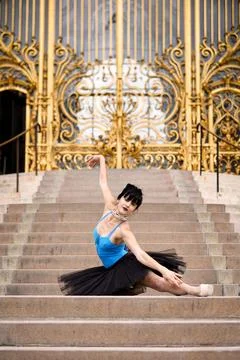 Ballet dancer posing on Paris staircase in front of golden gate June 15 2025 Stock Photos