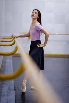 Ballet dancer practices at a dance studio in the evening showcasing moves near Stock Photos
