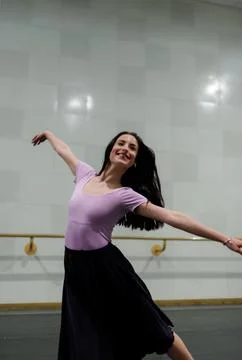 Ballet dancer practices movement in studio while smiling and enjoying the dance Stock Photos
