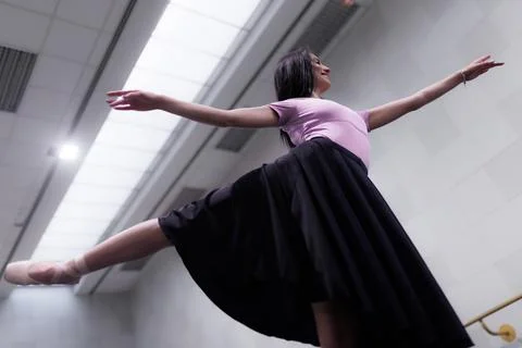 Ballet dancer practices in a studio with large windows and bright lighting Stock Photos