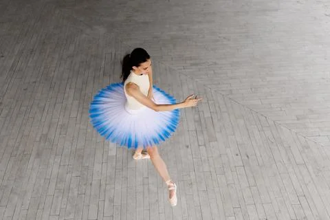 Ballet dancer practicing on pointe in a blue and white tutu, photographed from Stock Photos