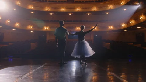 Ballet dancers bow down in front of rows of seats Stock Footage 238070963