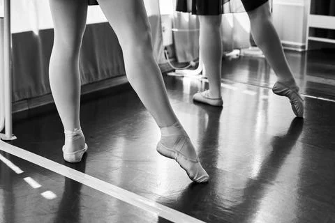 Ballet dancers practicing pointe technique in studio with monochrome light Stock Photos