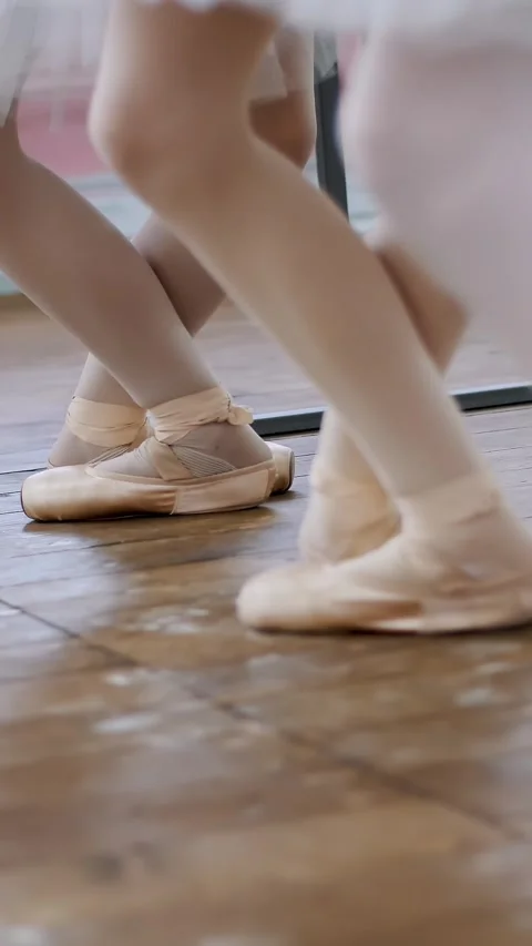 In ballet hall, Young ballerinas perform pas echappe in pointe shoes, goes up on Video stock 314322553