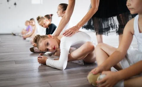 Ballet teacher and students ballerinas exercising in dance class in school Stock Photos