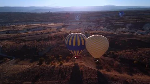 Balloon adventure view. Distant drones capture balloons drifting over rugged Stock Photos