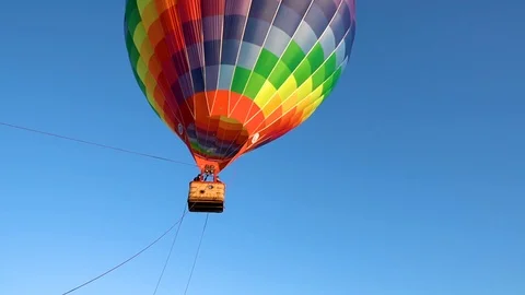 The balloon flies in clear skies. A multi-colored balloon. Aerostat Stock Footage 122563802