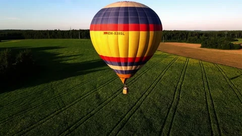 The balloon is flying close to the ground, next to the trees Stock Footage 205723574