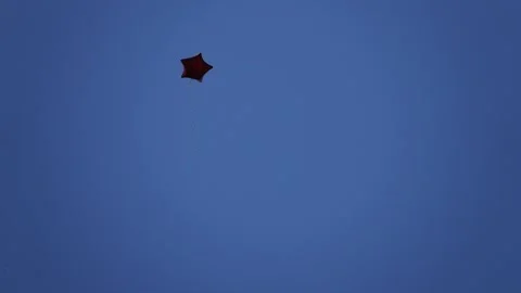Balloon in form of five-pointed star flies against background of blue sky. Stock Footage 214954428