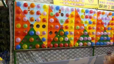 Balloon hit by dart, wall full of colorful balloons at shooting range Stock Footage 57891365