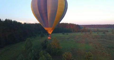 A balloon in the rays of the morning sun flies above the ground Stock Footage 82299341