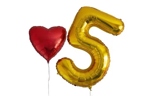 A balloon in the shape of the number five and a balloon in the shape of a heart Stock Photos