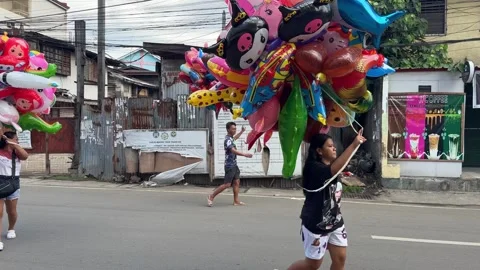 Balloon vendors walking along Colon Street on a Sunday morning. Stock Footage 285295941