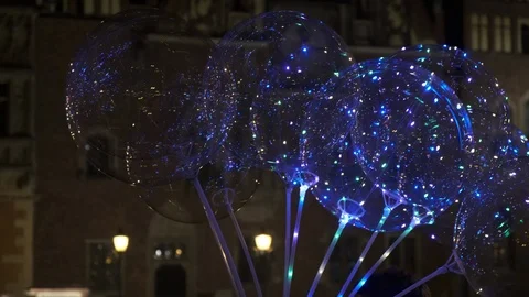 Balloons with colored LED lights are sold on the night city street Stock Footage 124355517