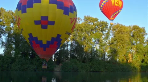 Balloons float over river Stock Footage 56463451