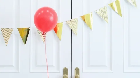 Balloons floating against door Stock Footage 95967581