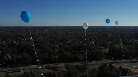 Balloons Floating on Tethers in a Blue Sky, Bryan, Texas, USA Video stock 144035406