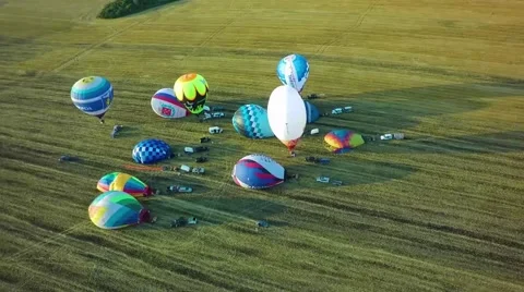 Balloons fly up in sky with passengers over green field Stock-Footage 66759145