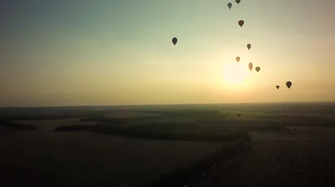 Balloons fly up in sky with passengers over green field Stock-Footage 66760173