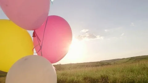 Balloons on a green meadow at sunset. Concept - lightness and freedom of Видео 76157012
