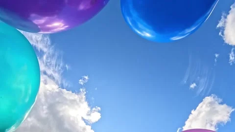 Balloons in mixed colors moving under scattered summer clouds Stock Footage 316046972