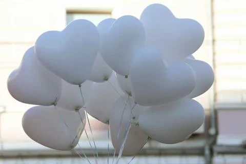 Balloons in the shape of a heart fluttering from the wind in the city Stock Photos