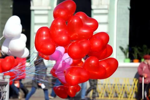 Balloons in the shape of a heart fluttering from the wind in the city. Stock Photos