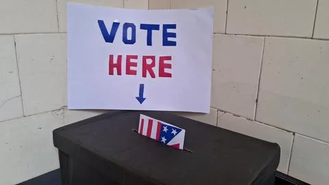 Ballot box with flag envelope placed under vote here sign Stock Photos