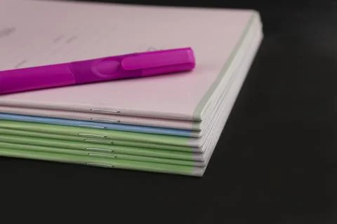 A ballpoint pen and a stack of school notebooks Stock Photos