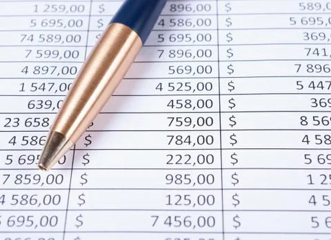 Ballpoint pen lying in a corner on printed financial tables Stock Photos