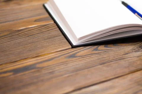 Ballpoint pen in open notebook on a dark brown wooden background. Blank pages 스톡 사진