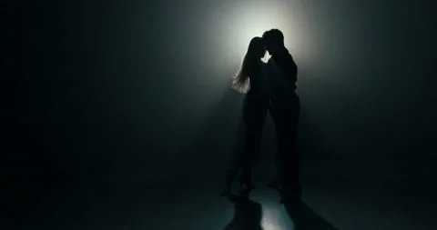 Ballroom dance between two partners shadows of figures on stage in dark room lit Stock Footage 161629071