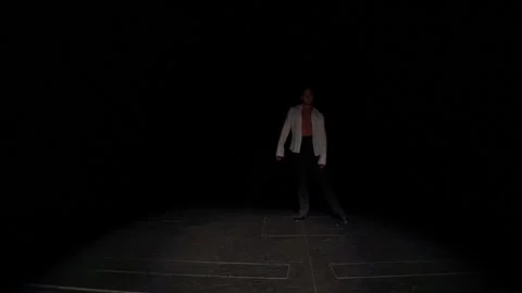 Ballroom dancer comes out of darkness onto marked stage with slow,flexible steps Stock Footage 166593644