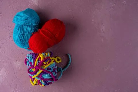 Balls of multi-colored threads for knitting on a pink background Stock Photos