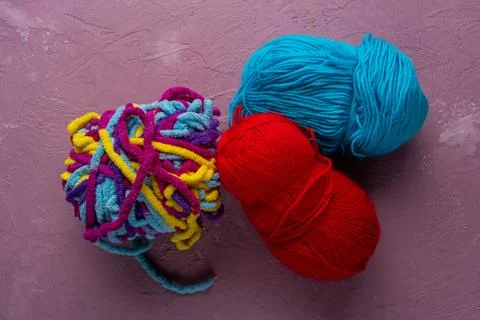 Balls of multi-colored threads for knitting on a pink background Stock Photos
