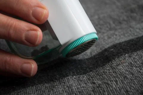 Balls shaving on grey woolen pullover Stock Photos