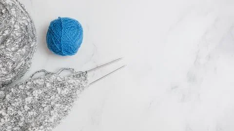 Balls of woolen thread and long metal needles on on light background Stock Photos