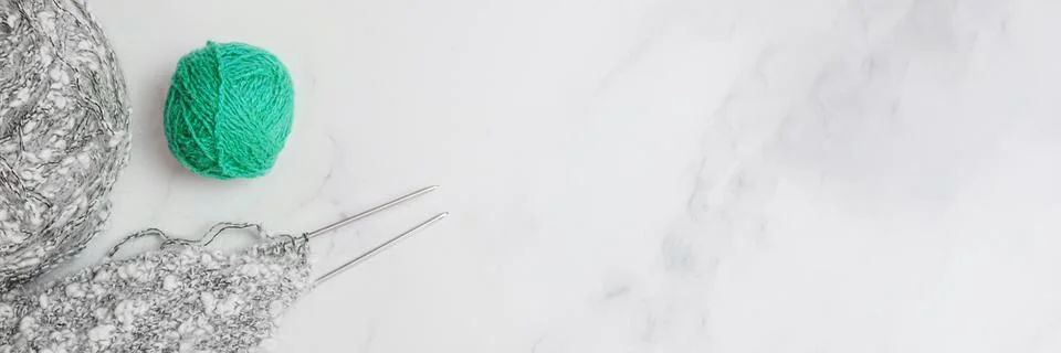 Balls of woolen thread and long metal needles on on light background Stock Photos