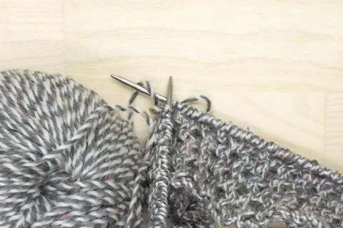 Balls of yarn and started knitting cloth on knitting needles. Stock Photos
