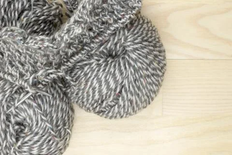 Balls of yarn and started knitting cloth on knitting needles. Stock Photos