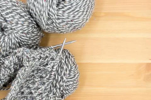 Balls of yarn and started knitting cloth on knitting needles. Stock Photos