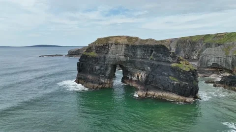 Ballybunion Arch beach Ireland cliffs rock stone, low waves, clear sky Stock Footage 217819680