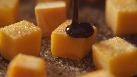 Balsamic vinegar poured on pumpkin cubes covered by brown sugar Stock Footage 135017990