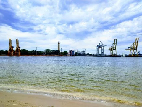 Baltic Harbor Cranes Frame Historic Lighthouse 스톡 사진