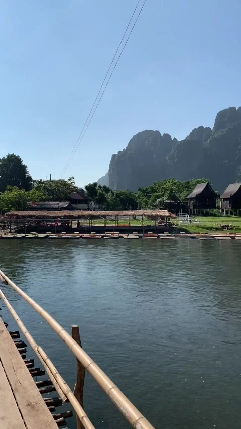 Bamboo bridge on a river in Vang Vieng Stockbeeldmateriaal 343320238