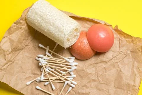 Bamboo ear sticks, loofah, solid shampoo and conditioner on kraft paper. Stock Photos