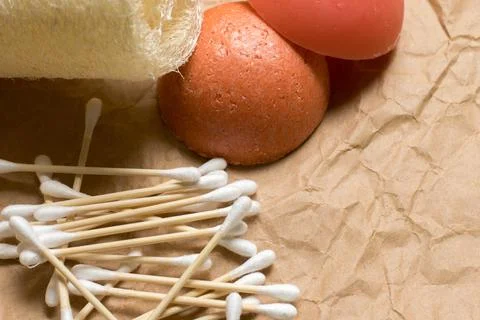 Bamboo ear sticks, loofah, solid shampoo and conditioner on kraft paper. Stock Photos