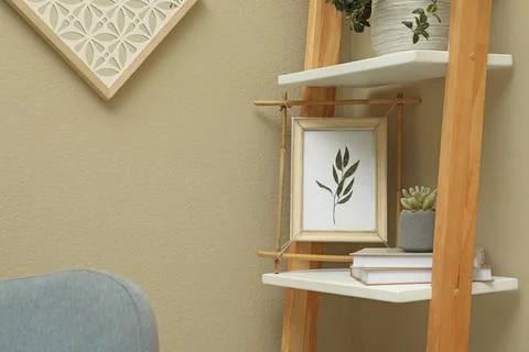 Bamboo frame and different decor elements on shelving unit indoors 写真素材
