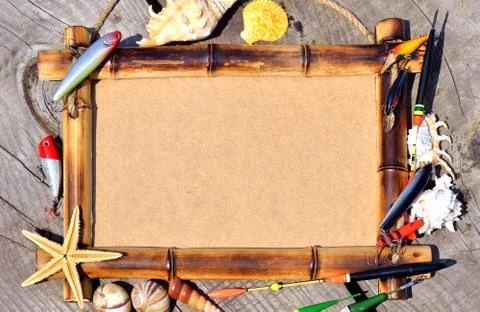 Bamboo frame decorated with shells and fishing tackle on wood Stock Photos